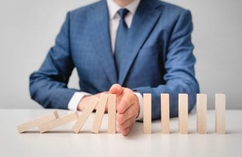 domain-blocking-man-blocking-dominoes-from-falling-down-with-his-hand